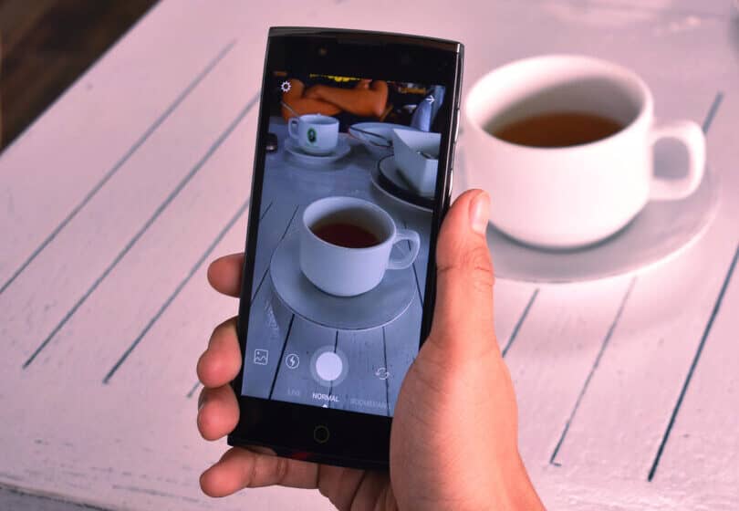 Hand som håller i en telefon och skapar en händelse på Instagram